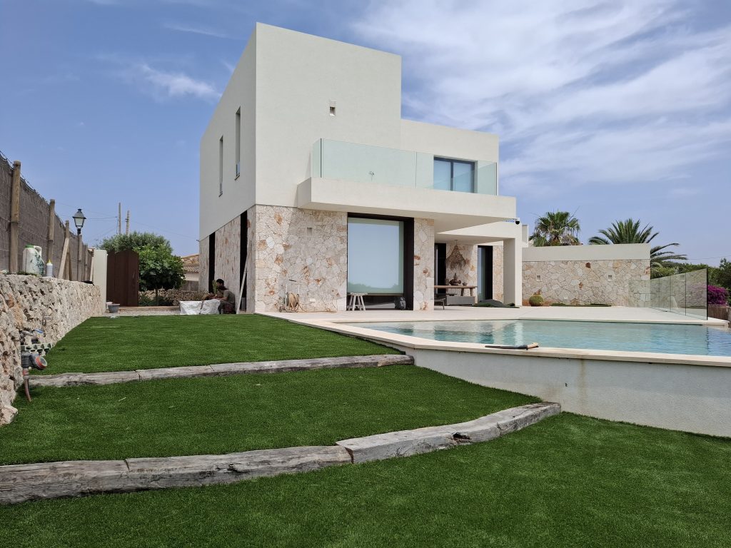 Entrada de vivienda unifamiliar con césped artificial de alta densidad